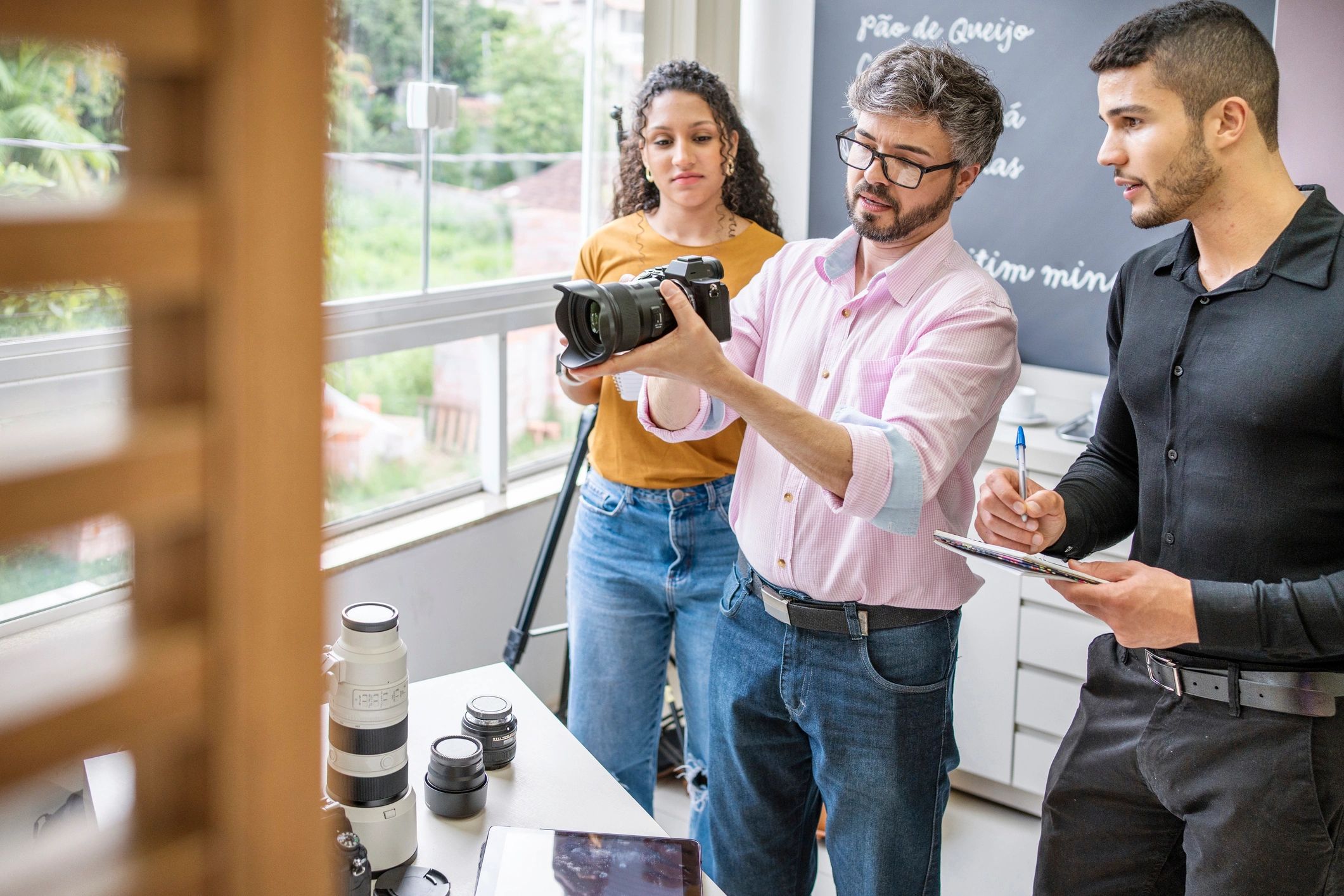 Photographer reviewing camera equipment with assistants in a studio