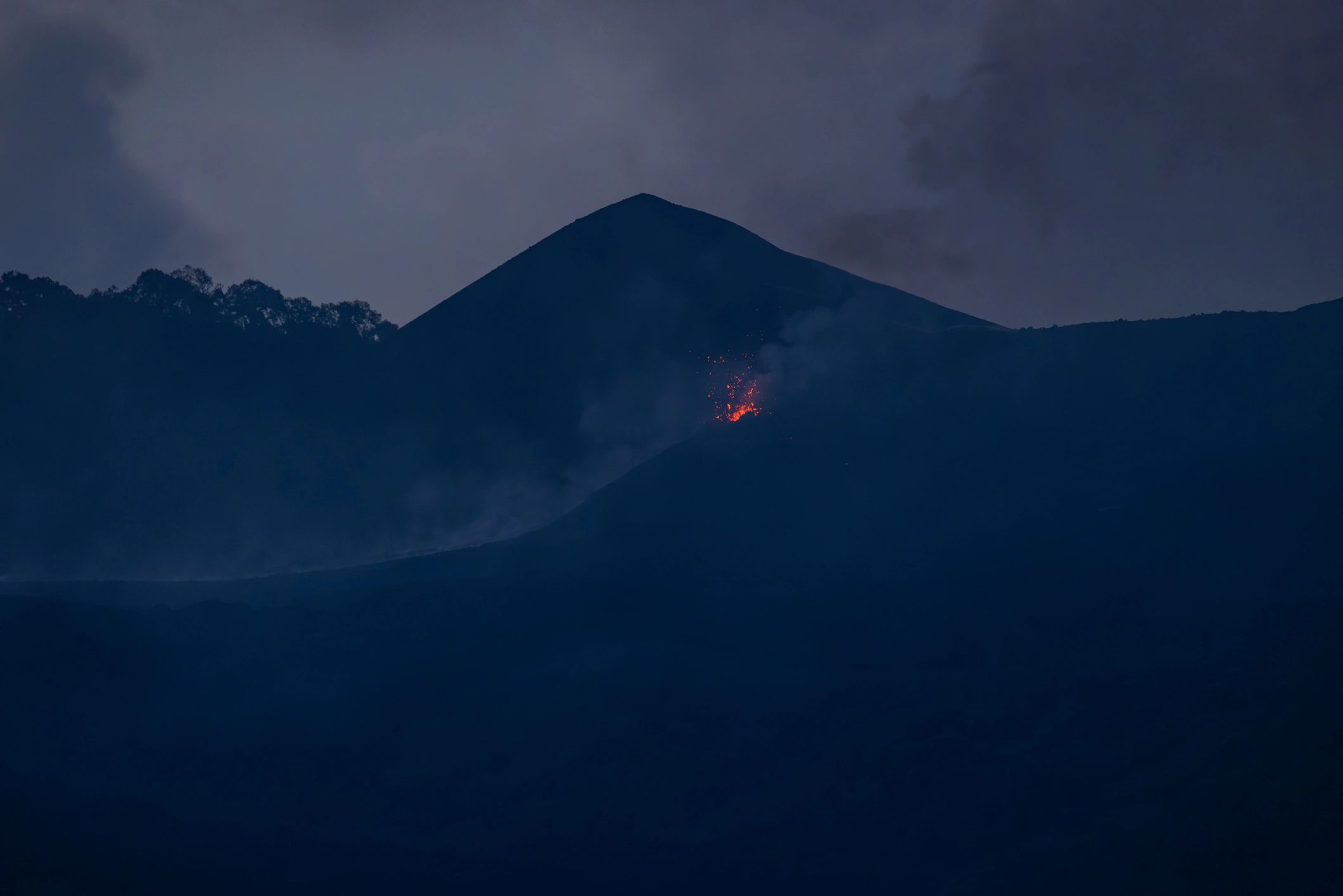 Lava flow and steam inside an active volcanic crater