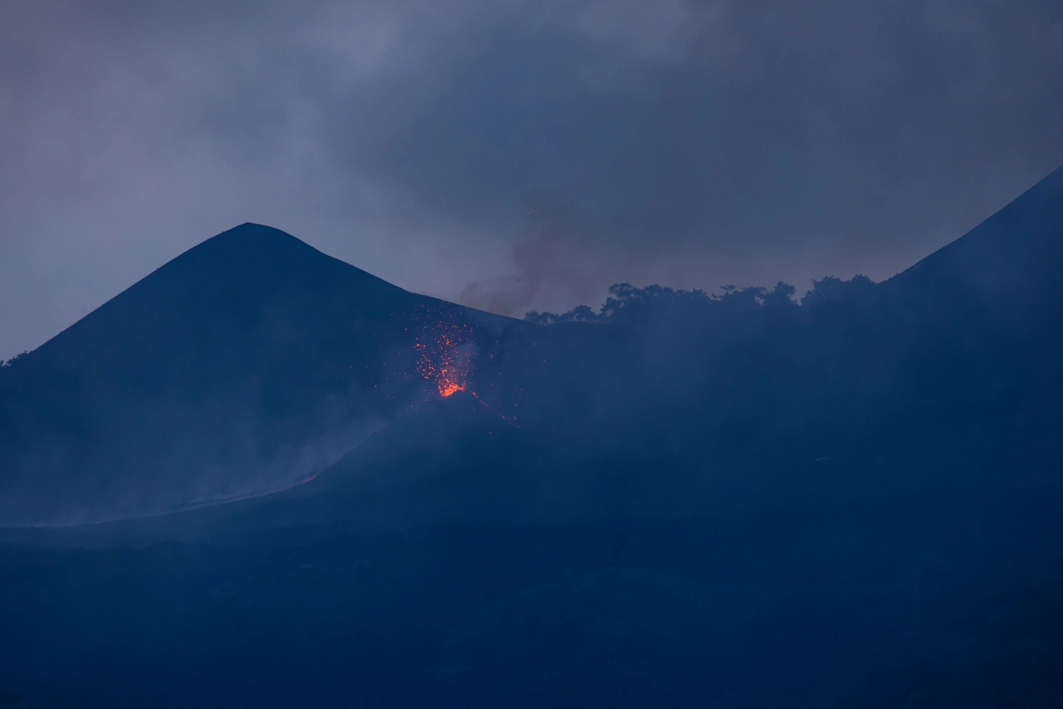 Volcanic crater with lava flow and smoke