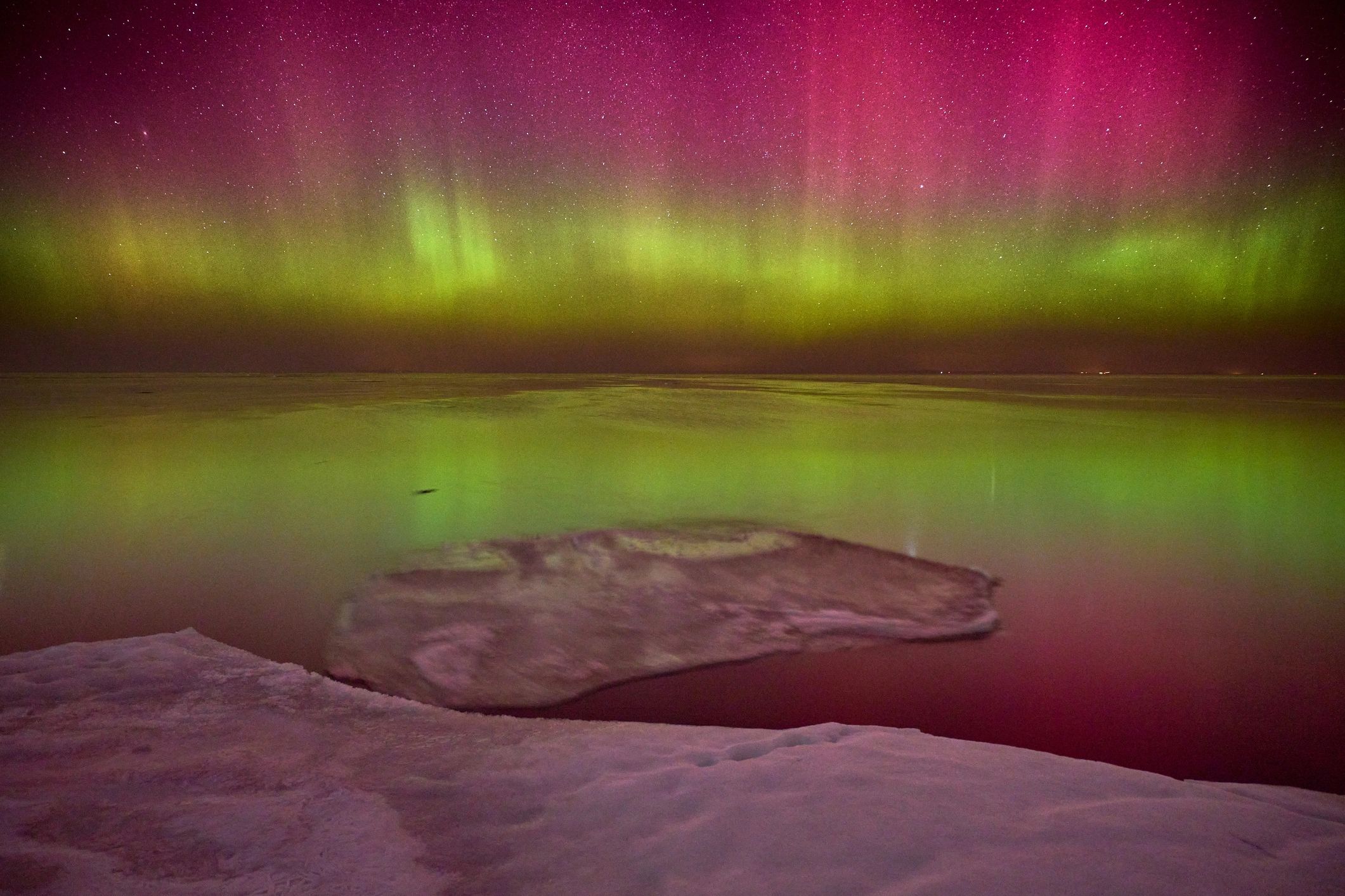 Aurora borealis over a frozen coastline at night